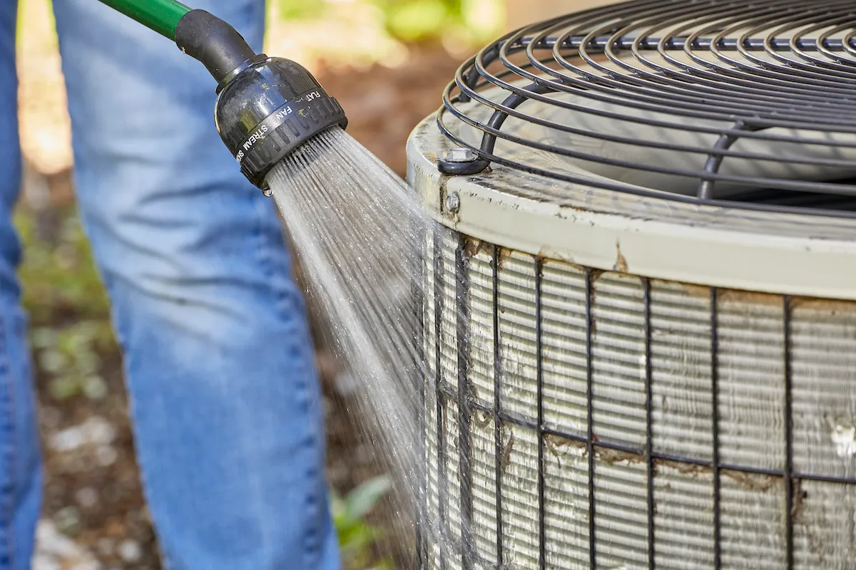 Technician cleaning a condenser coil in Harlingen